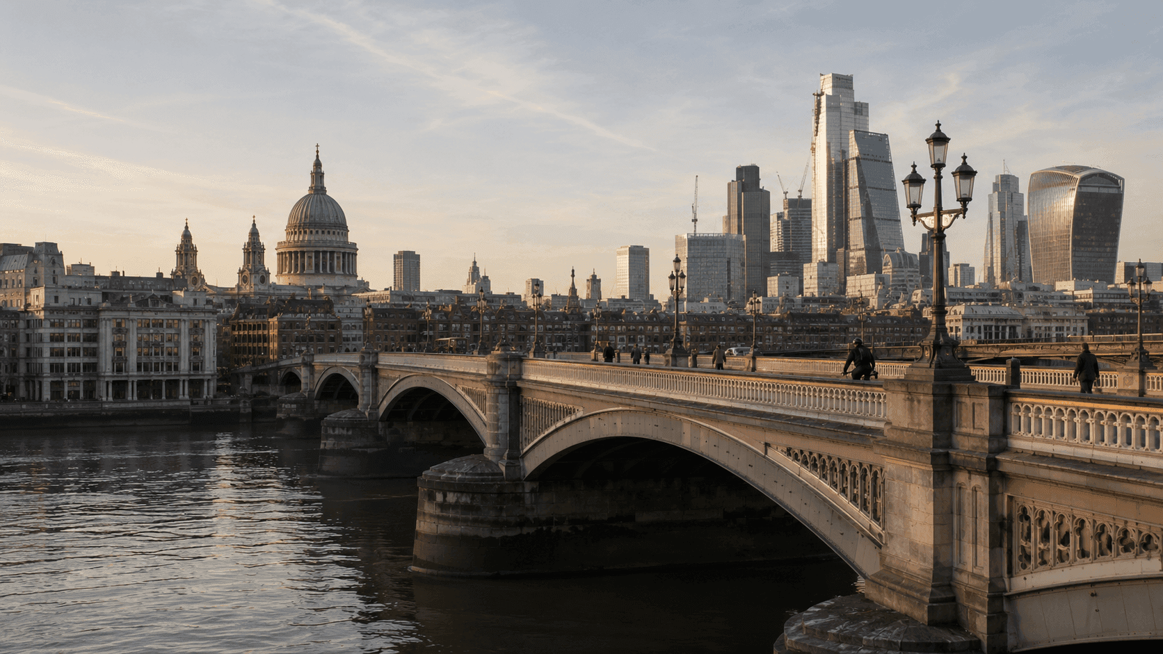 London Bridge over the Thames at dawn with the City of London skyline visible behind it on a clear morning